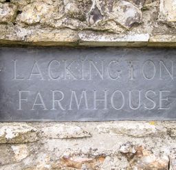 A stone plaque engraved with Lackington Farmhouse embedded in a stone wall at The Coach House at Lackington Farm in Piddletrenthide