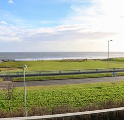 A seafront view with a grass park and a road in front at Sandy Corner in Blyth Northumberland