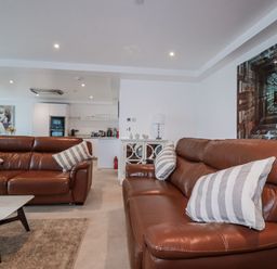 A living room with leather sofas and a coffee table at 13 Cliff Edge in Newquay