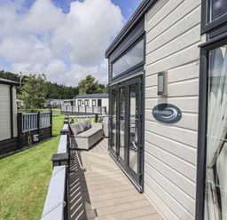 Exterior balcony with seating area and glass doors on a house at Yealands 27 in South Lakeland Leisure Village near Carnforth