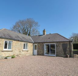 A house with a gravel area and trees at Whinney Moor in 