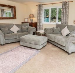 A living room with sofas and a decorative rug at Whinney Moor in Alnwick