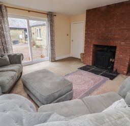 A living room with a sofa and fireplace at Whinney Moor in Alnwick