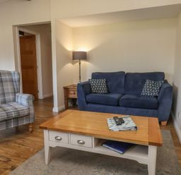 A living room with a blue sofa and armchair at Bugle in Saltburn-By-The-Sea