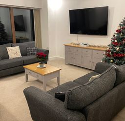 A living room with a sofa and Christmas tree at Pol View in Helston