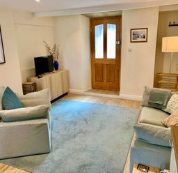 A living room with a sofa and television at Bobbin Cottage in Swanage