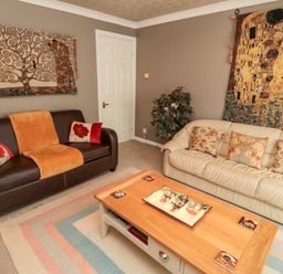 A living room with two sofas a coffee table and wall tapestries at Tartaria in Widdrington