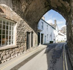A street with stone archway and white buildings along the road at 1 Tower House in Cartmel