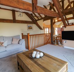 A living room with a gray sofa and wooden coffee table with decorative balls at Oak Cottage in North Molton