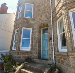 A front entrance with a blue door and windows at Heron in St Ives