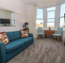 A living room with a sofa and chairs at Heron in St Ives