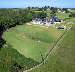An aerial view of a house with a large fenced lawn and a gazebo in a rural area at Rynys in Llanddeiniolen near Llanrug