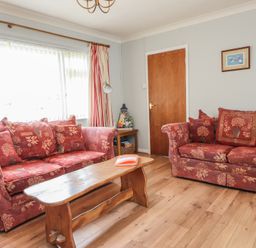 A living room with sofas and a coffee table at Bro Mebyd in Criccieth