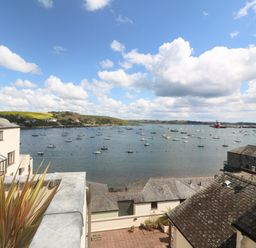 View of a harbor with many boats moored on water and buildings in the foreground at 58 High Street in Falmouth