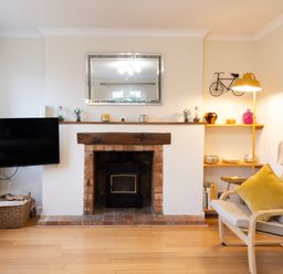 A living room with a fireplace and television at White Stones in Fulbrook, near Burford