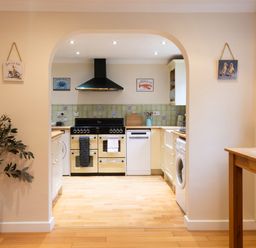 A kitchen with appliances and a table at White Stones in Fulbrook, near Burford