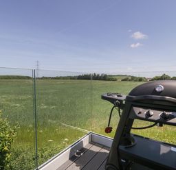 A balcony with a barbecue grill overlooking a green field at Little Knaplock in Fiddington near Combwich Somerset