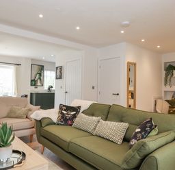 A living room with green and beige sofas and a plant on a coffee table at Rydal Rock in Ambleside