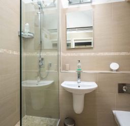 A bathroom with a shower, a sink with soap and a mirror at Lanes Cottage in Chipping Campden