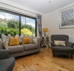 A living room with a sofa and armchair at Bell Garden in Stow-On-The-Wold