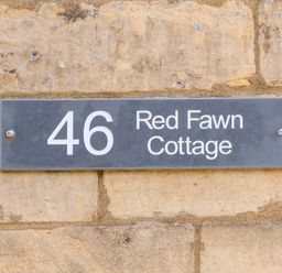 A house number sign with 46 Red Fawn Cottage on a stone wall at Red Fawn Cottage in Blockley