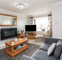 A living room with a sofa armchair coffee table and television at Beach View House in Wyke Regis