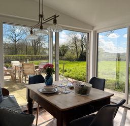 A dining room with a table set for meal at Pensarngerrig in Rhydlewis