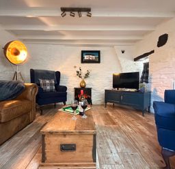 A living room with a sofa and armchairs at Pensarngerrig in Rhydlewis