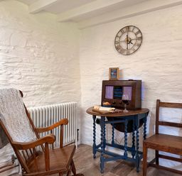 A sitting area with a rocking chair and table at Pensarngerrig in Rhydlewis