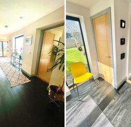 A hallway with dark wood flooring a stairway a runner rug a glass console table with plants a wooden door and a yellow chair next to a large window at Avalennek in St Newlyn East