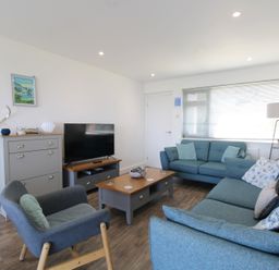 A living room with a sofa and armchair at 65 Channel View in Ilfracombe