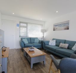 A living room featuring sofas and a television at 65 Channel View Ilfracombe