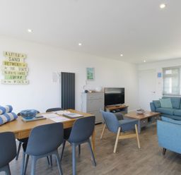 A living room with a dining area and a television at 65 Channel View Ilfracombe