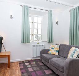 A living room with a television and a sofa at Nest Cottage in St Tudy