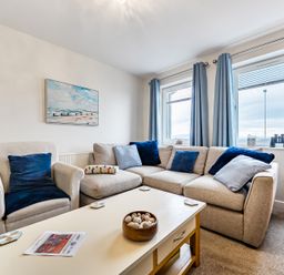 A living room with a sofa and coffee table at Solway View in Skinburness near Silloth