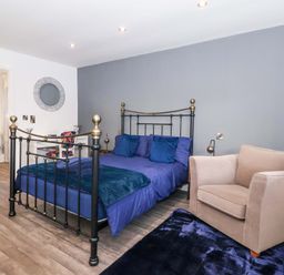 A bedroom with a bed and chair at Chalet 1 in Sherburn