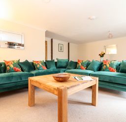 A living room with green sofas and a wooden coffee table at Wheal Prosper@The West Dry in St Austell