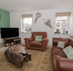 A living room with a television and sofas at Awen Ingli, Newport, Pembrokeshire