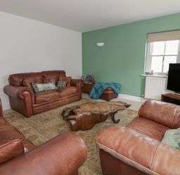 A living room with sofas and a coffee table at Awen Ingli in Newport, Pembrokeshire