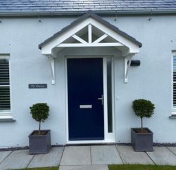 A front door with two potted plants on either side at Ty Owen in Newport Pembrokeshire