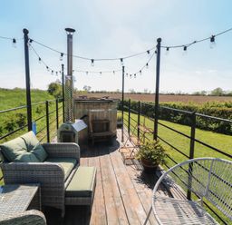 An outdoor terrace with seating and a hot tub at Sweet Caroline Shepherd’s Hut Low Marnham near Sutton-On-Trent