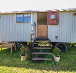 A shepherd's hut with stairs and a bench at Sweet Caroline Shepherd’s Hut in Low Marnham near Sutton-On-Trent
