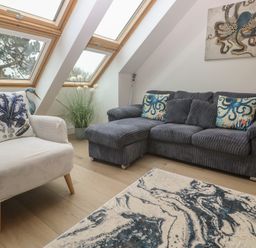 A living room with a sofa and armchair at Upper Deck in Truro