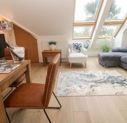 A living room with a sofa and dining table at Upper Deck in Truro