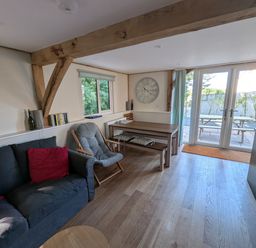 A living room with a sofa and a dining table at Roman Lodge in Osmington