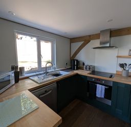 A kitchen with sink, oven, and appliances at Roman Lodge in Osmington