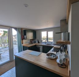 A kitchen with a sink and microwave at Roman Lodge in Osmington