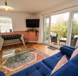 A living room with a foosball table and a television at Lake View in Bowness-On-Windermere