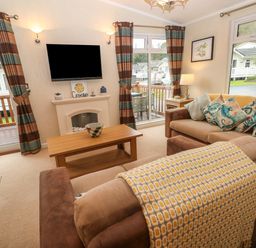 A living room with sofas coffee table and television at 16 Heritage Park Heritage Park near Kilgetty