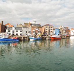 A harbor with boats docked in front of buildings along the waterfront at Amaranta Brewers Quay Harbour